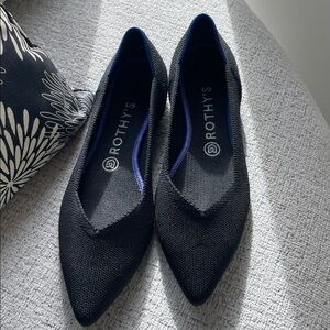 Rothy’s The Point Black Flats. Blue trim. These look new. Nice sheen on fabric.